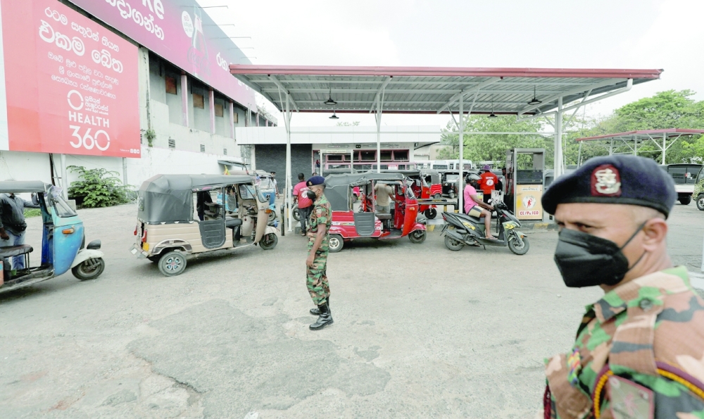 Soldiers help fuel station distribute oil in Colombo. -- Reuters