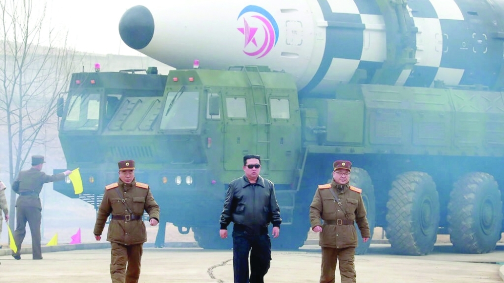 North Korean leader Kim Jong Un walks towards the camera, flanked by generals, as they prepare to fire the giant Hwasong-17 missile. -- AFP