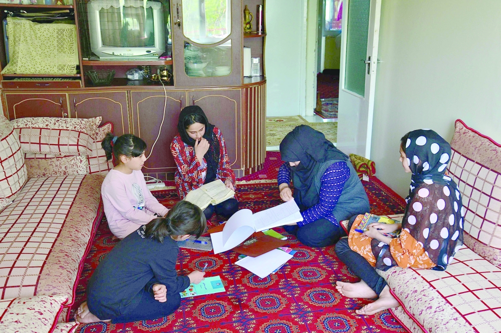 Girls study at home with their mother in Kabul. -- AFP