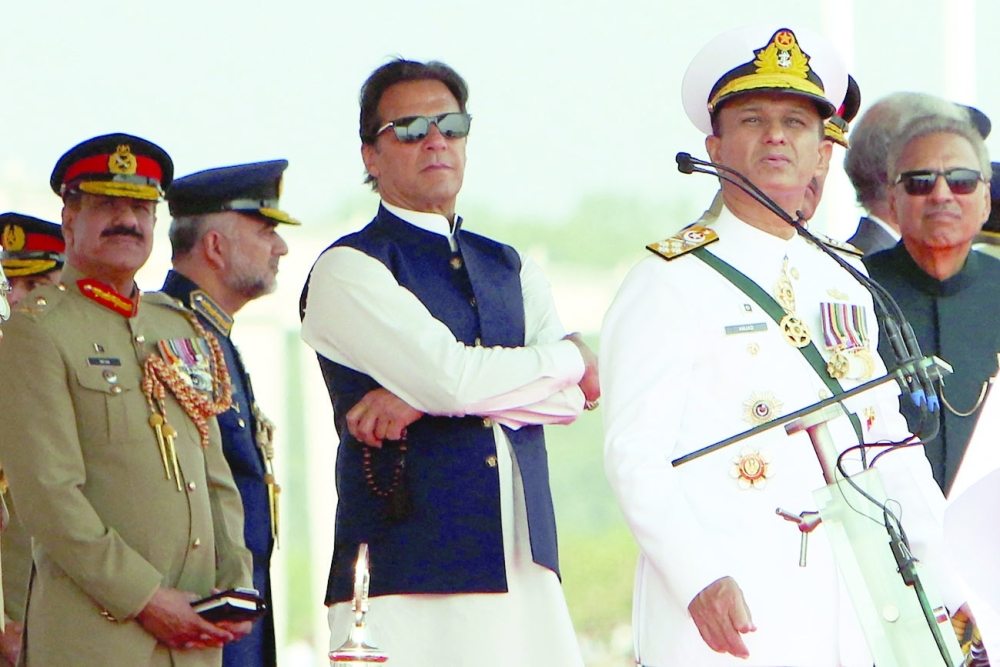 Pakistan's Prime Minister Imran Khan (C) and President Arif Alvi (R) watch Pakistan's Air Force fighter jets perform during the Pakistan Day parade in Islamabad on March 23, 2022. (Photo by Ghulam Rasool / AFP)