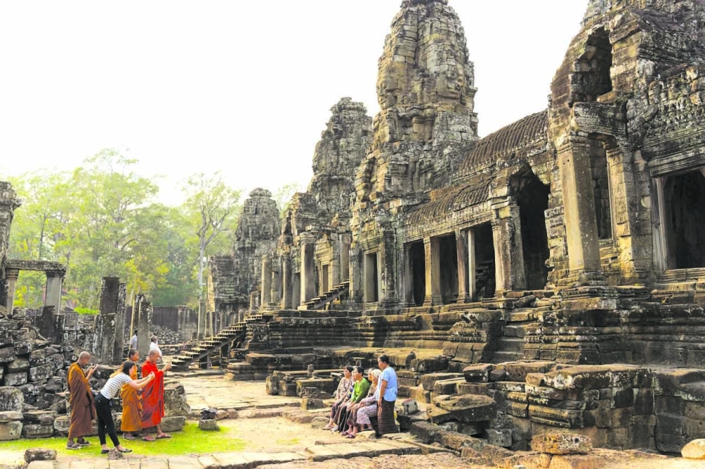 Visitors at the Bayon temple in Siem Reap, Cambodia, Feb. 26, 2022. (Thomas Cristofoletti/The New York Times)