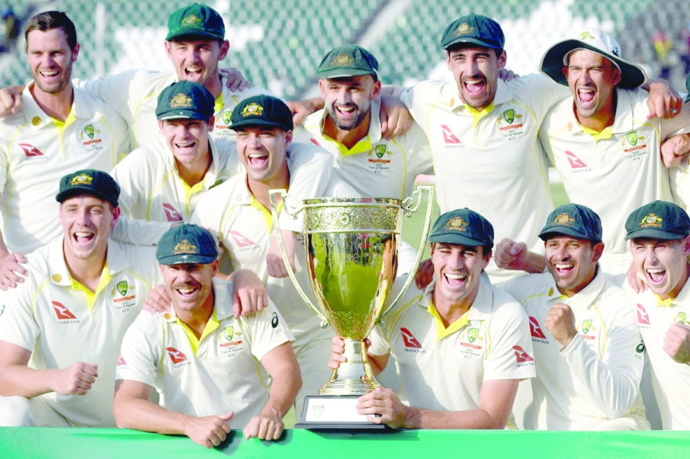 Australia's players pose with the trophy after winning the third and final Test against Pakistan, in Lahore. -- AFP
