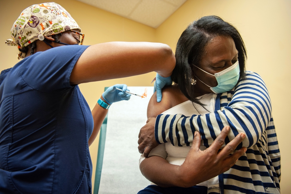 Mia Collins gives a COVID-19 booster vaccination to Sharon Scott in Cleveland, Miss., Jan. 6, 2022. (Rory Doyle/The New York Times)