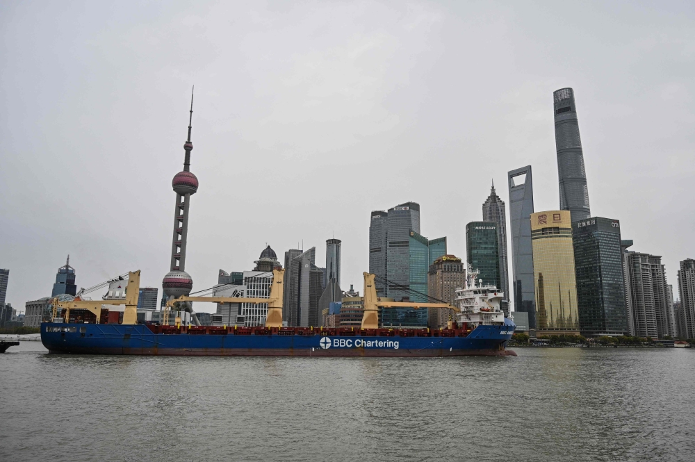 A ship sails along the Huangpu River as buildings (back) are seen in Pudong district that is in lockdown as a measure against the Covid-19 coronavirus, in Shanghai on March 28, 2022.