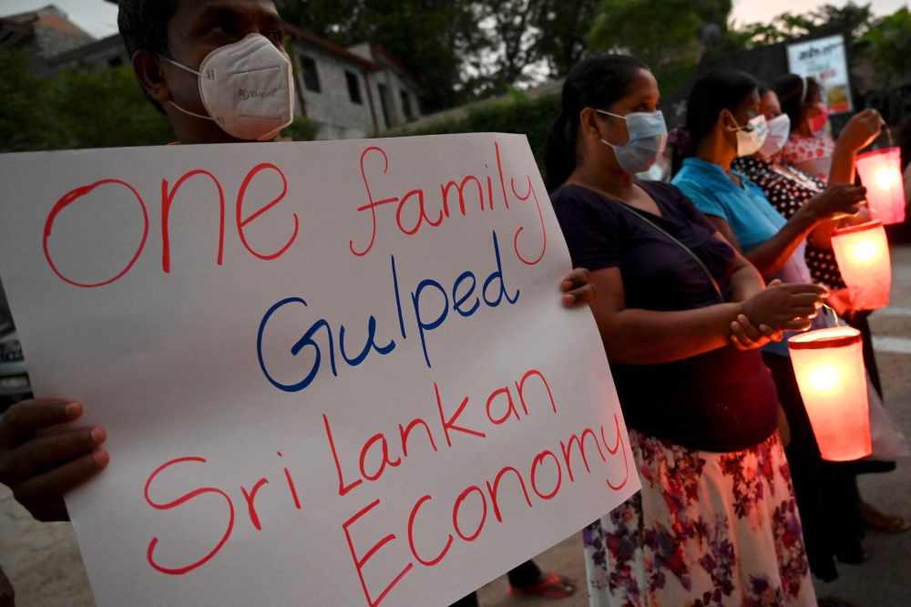 People take part in a demonstration to denounce the shortage of cooking gas, kerosene oil and other essential commodities on the outskirts of Colombo on March 27, 2022. 