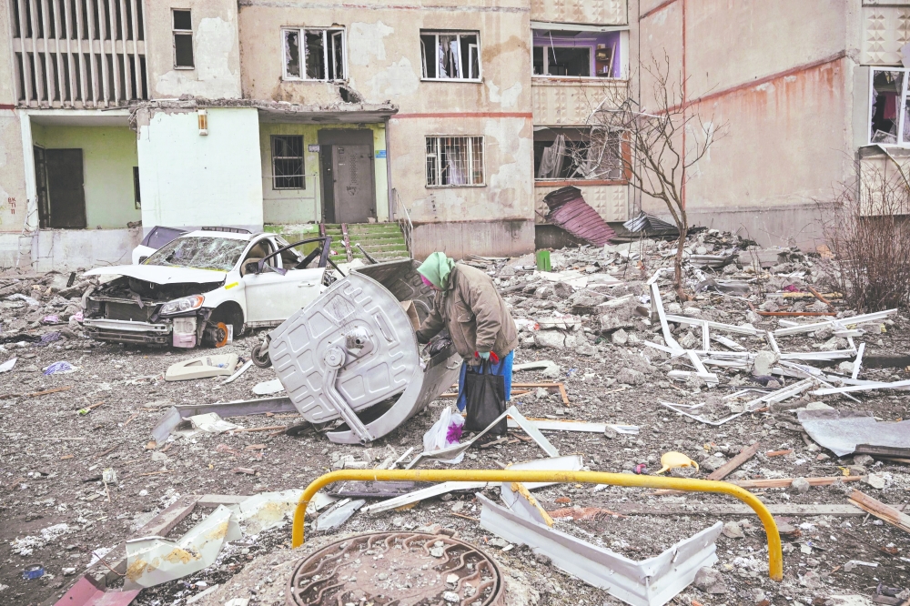An elderly woman stands amid rubbles near a damaged apartment building at a front line district of Kharkiv amid Russian war on Ukraine. - AFP 