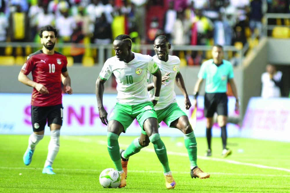 Senegal's Sadio Mane (C) controls the ball during the World Cup 2022 qualifying football match between Senegal and Egypt at the  Me Abdoulaye Wade Stadium in Diamniadio on March 29, 2022. (Photo by SEYLLOU / AFP)

