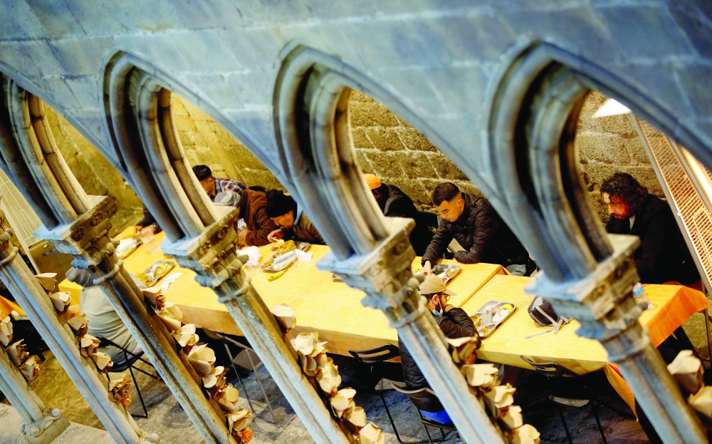 People eat during a charity Ramadhan dinner in the cloister at Santa Anna church during the coronavirus disease outbreak, in Barcelona. — Reuters