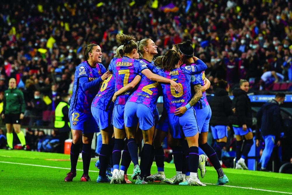 Barcelona's players celebrate after scoring a goal during the Women's Champions League quarterfinal second leg match against Real Madrid. -- AFP