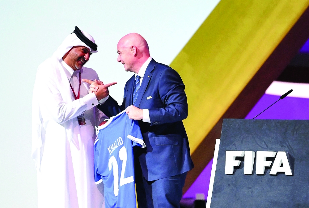 Fifa President Gianni Infantino (R) gives a jersey to the Prime Minister of the State of Qatar, Shaikh Khalid bin Khalifa al Thani, during the 72th Fifa Congress in the Qatari capital Doha on March 31, 2022. The countdown towards the most controversial World Cup in history really begins on Friday as the draw for Qatar 2022 takes place in Doha, less than eight months before the start of the tournament itself. (Photo by FRANCK FIFE / AFP)
