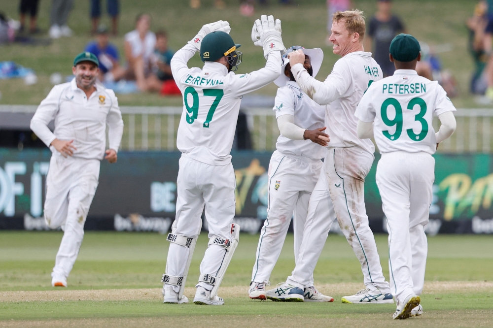 South Africa's Simon Harmer (2nd R) celebrates with team-mates after the dismissal of Bangladesh's Najmul Hossain Shanto. -- AFP