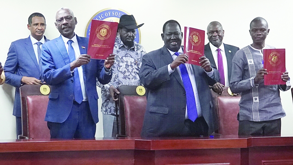 Vice-President of Sudan Mohamed  Hamdan, South Sudanese President Salva Kiir, and South Sudan's opposition leader Riek Machar, witness from back row the signing ceremony of the two leaders in a sealed agreement in Juba. - AFP


