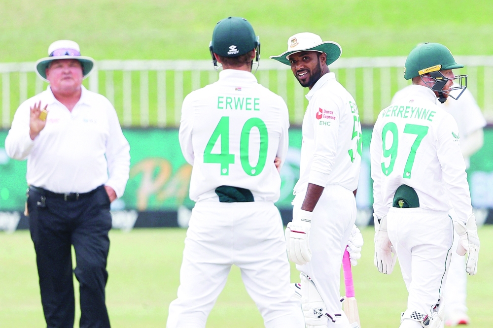 Bangladesh's Ebadot Hossain (2nd R) banters with South Africa's Sarel Erwee (2nd L) during the fifth day of the first Test cricket match between South Africa and Bangladesh at the Kingsmead stadium in Durban on April 4, 2022. (Photo by Marco Longari / AFP)

