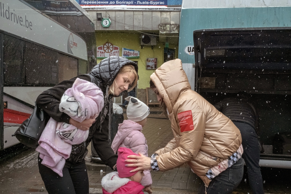 Mariia Seniuk, left, with her two daughters, arrives from Szczecin, Poland, at the main bus terminal in Lviv, Ukraine on Sunday, April 3, 2022. (Mauricio Lima/The New York Times)