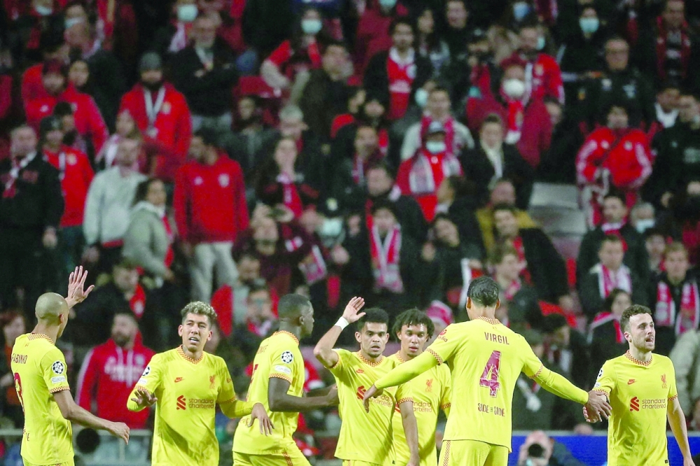 Liverpool's Colombian midfielder Luis Diaz (C) celebrates with teammates after scoring his team's third goal during the UEFA Champions League quarter final first leg football match between SL Benfica and Liverpool FC at the Luz stadium in Lisbon on April 5, 2022. (Photo by CARLOS COSTA / AFP)

