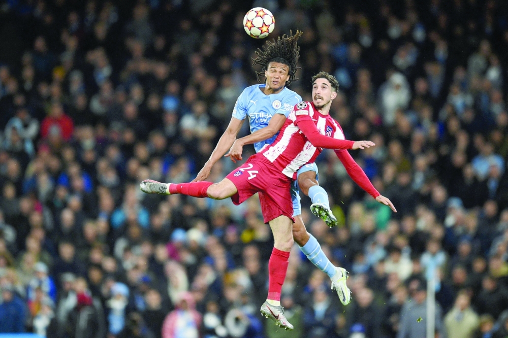 TOPSHOT - Manchester City's Dutch defender Nathan Ake (L) vies with Atletico Madrid's Croatian defender Sime Vrsaljko (R) during the UEFA Champions League Quarter-final first leg football match between Manchester City and Atletico Madrid at the Etihad Stadium in Manchester, north west England, on April 5, 2022.  (Photo by Oli SCARFF                           / AFP)

