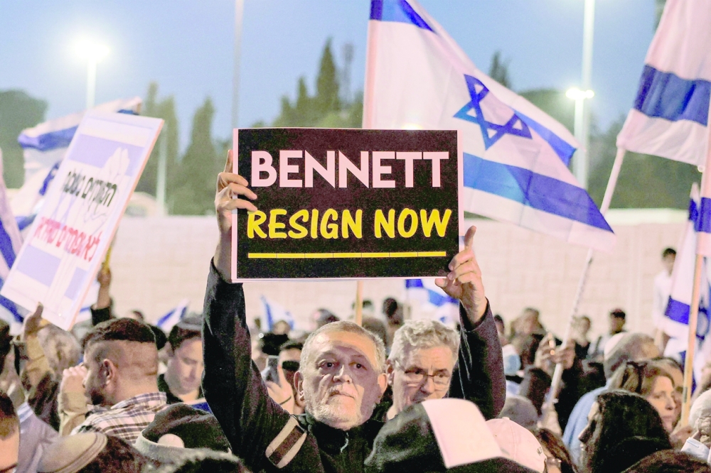 A man holds up a sign reading in English "[Israeli Prime Minister Naftali] Bennett resign now" during an anti-government protest by Israeli right-wing supporters in Jerusalem on Wednesday. - AFP