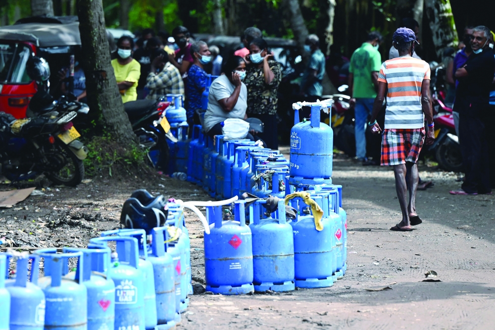 People queue to buy LPG cylinders in Colombo. - AFP