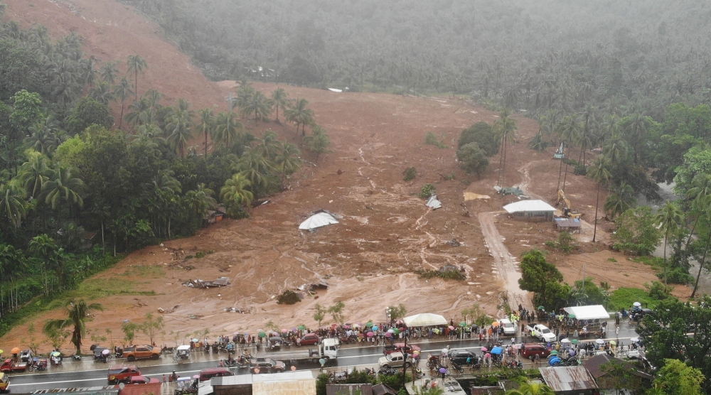 This aerial photo shows the collapsed mountain side and buried houses in the village of Bunga, Baybay town, Leyte province, in southern Philippines on April 12, 2022, a day after a landslide slammed into the village due to heavy rains brought about by tropical storm Megi. 