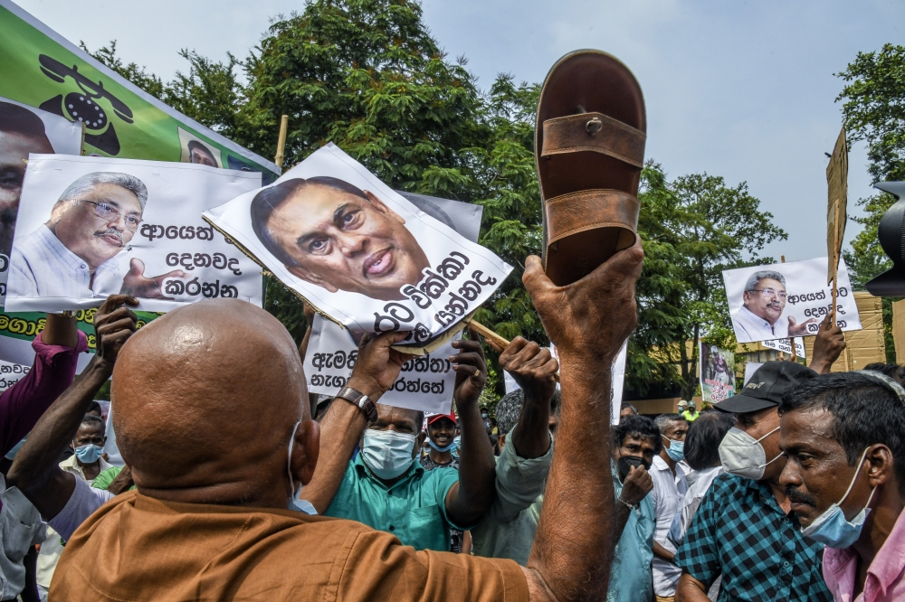 Thousands demonstrate against the government of Gotabaya Rajapaksa, seen in signs at left and right, over power cuts and the lack of essential products in Colombo, Sri Lanka, March 15, 2022. (Atul Loke/The New York Times)