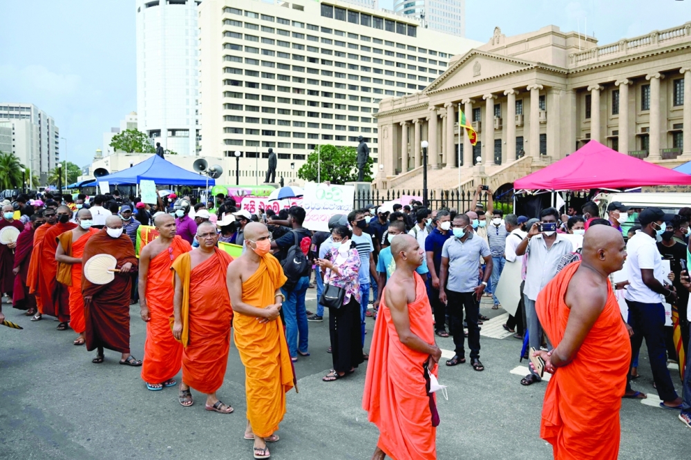 Monks take part in a demonstration against the economic crisis at the entrance of the president's office in Colombo. - AFP