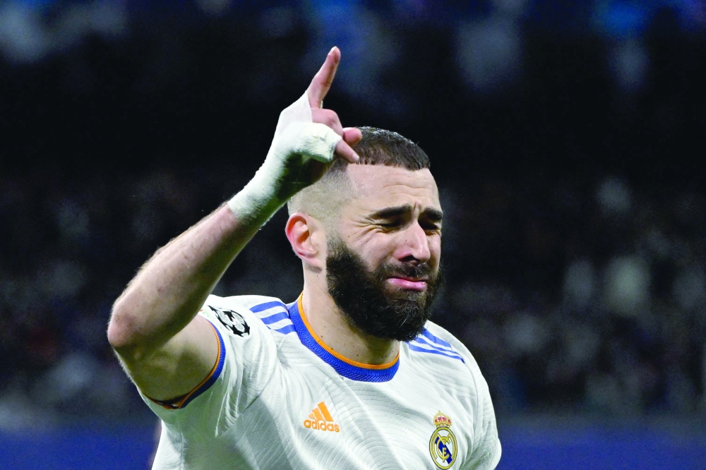 TOPSHOT - Real Madrid's French forward Karim Benzema celebrates after scoring a goal during the UEFA Champions League quarter final second leg football match between Real Madrid CF and Chelsea FC at the Santiago Bernabeu stadium in Madrid on April 12, 2022.  (Photo by PIERRE-PHILIPPE MARCOU / AFP)

