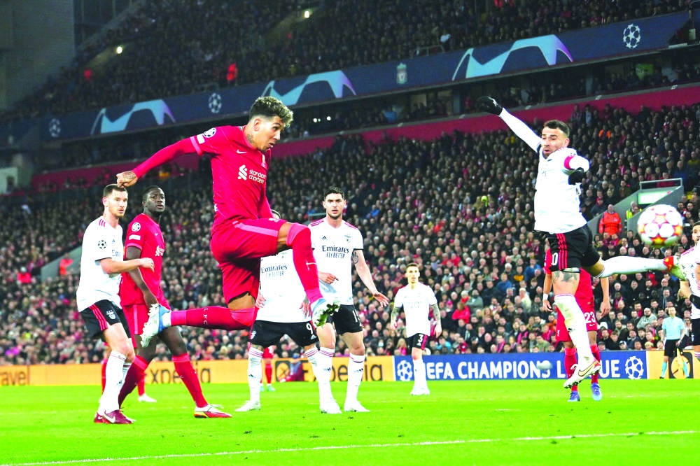 Liverpool's Brazilian midfielder Roberto Firmino scores his team third goal during the UEFA Champions League quarterfinal second leg football match between Liverpool and Benfica at the Anfield stadium, in Liverpool. -- AFP