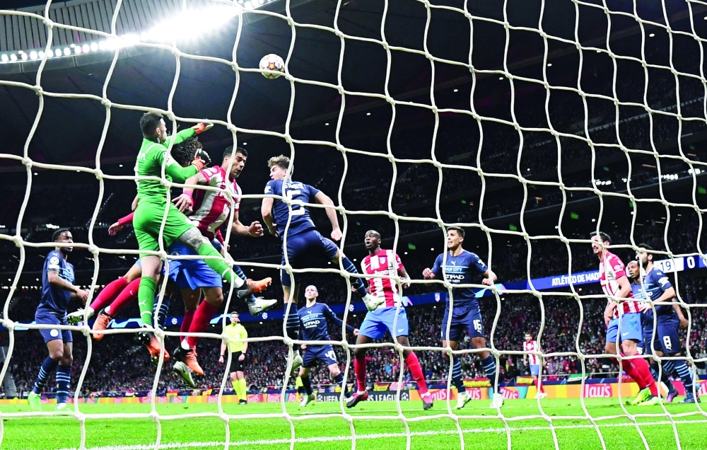 Manchester City's Brazilian goalkeeper Ederson (2L) clears the ball during the UEFA Champions League quarterfinal second leg football match between Club Atletico de Madrid and Manchester City FC at the Wanda Metropolitano stadium in Madrid on April 13, 2022. (Photo by PIERRE-PHILIPPE MARCOU / AFP)