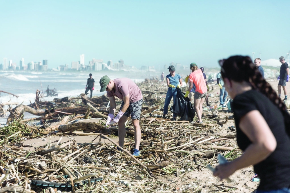 Volunteers of the local Durban community undertake to clean up the massive debris at the Blue Lagoon beach in Durban. - AFP