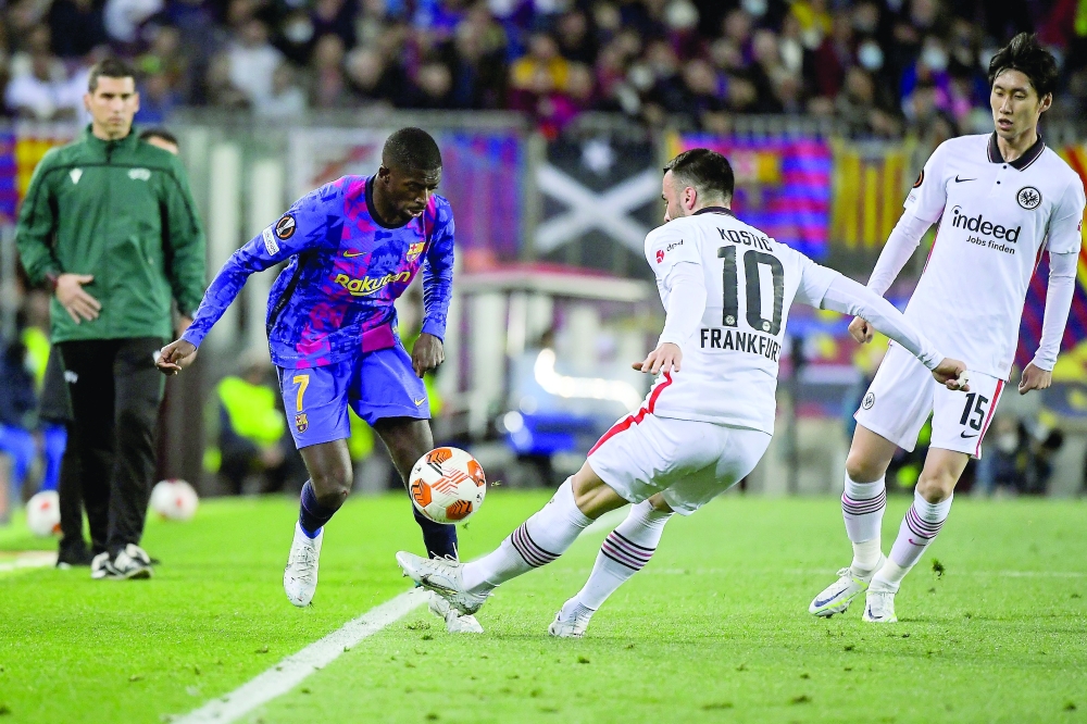 Barcelona's French forward Ousmane Dembele (L) fights for the ball with Eintracht Frankfurt's Serbian midfielder Filip Kostic during the Europa League quarter final second leg football match between FC Barcelona and Eintracht Frankfurt at the Camp Nou stadium in Barcelona on April 14, 2022.  (Photo by Jose Jordan / AFP)

