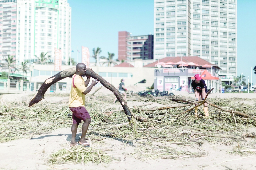 Volunteers and members of the public clean up the massive debris at the North Beach following heavy rains earlier the week in Durban, on Friday. - AFP