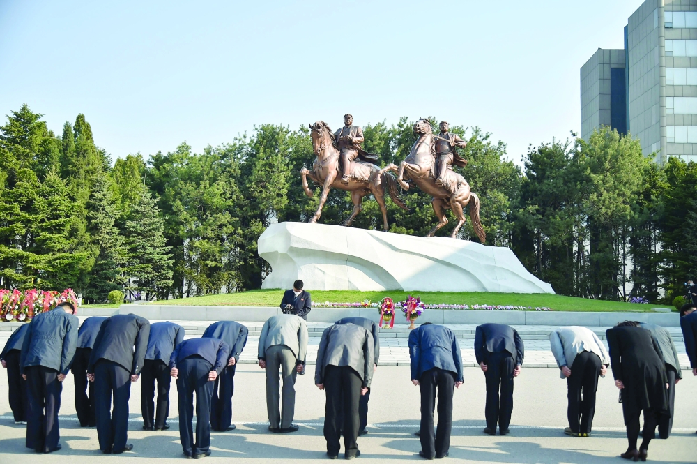People bow before the statues of late North Korean leaders Kim Il Sung and Kim Jong Il at the Mansudae Art Studio, as part of celebrations marking the 110th anniversary of the birth of Kim Il Sung, known as the "Day of the Sun", in Pyongyang on Friday. - AFP