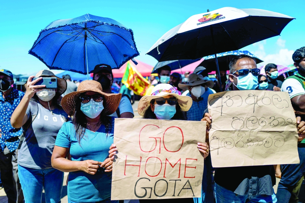 People display placards during an ongoing anti-government demonstration outside the president's office in Colombo on Friday, demanding the resignation of President Gotabaya Rajapaksa over the country's crippling economic crisis. - AFP