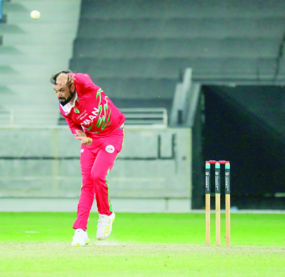 Oman's Bilal Khan bowls against Scotland.