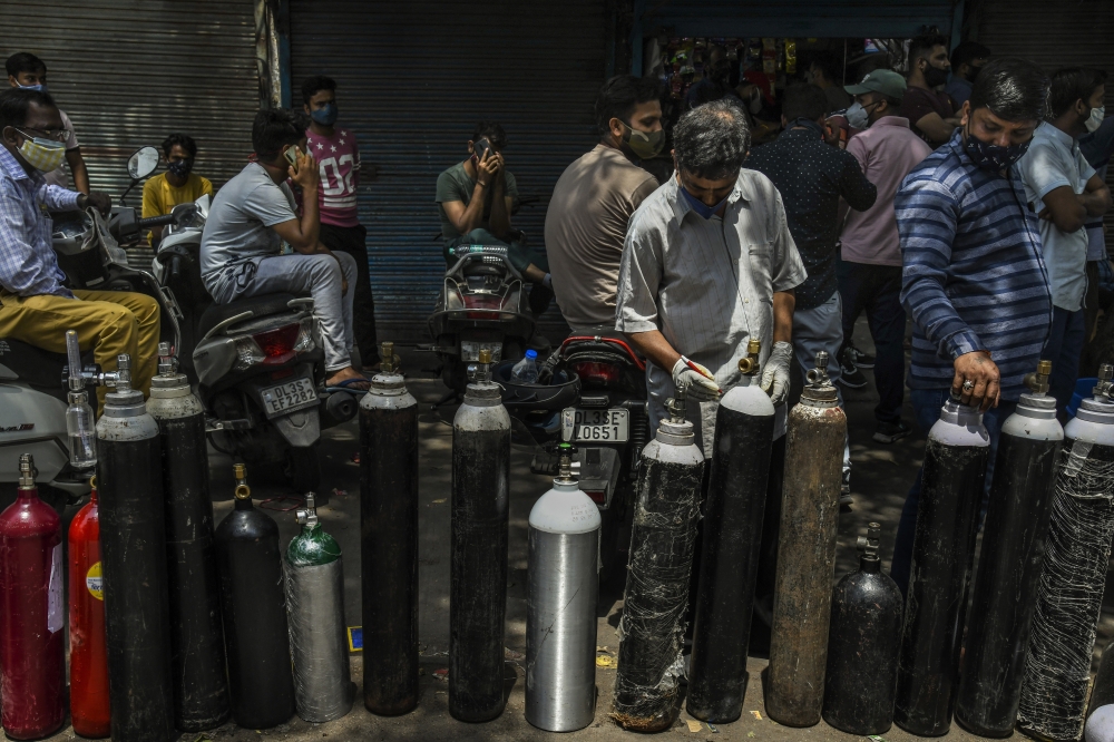 People wait to refill oxygen cylinders for COVID patients in New Delhi, April 27, 2021. (Atul Loke/The New York Times)