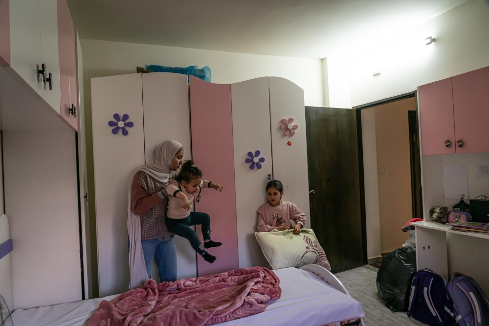 Israa Awartani and her daughters tidying up their bedroom, at home in Jenin, in the West Bank, on April 15, 2022. (Samar Hazboun/The New York Times)