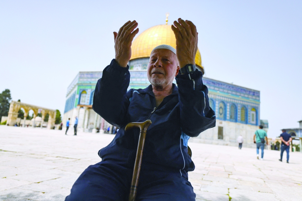 A Palestinian man prays in front of the Dome of Rock mosque at the Al Aqsa mosque compound in Jerusalem's Old City. - AFP