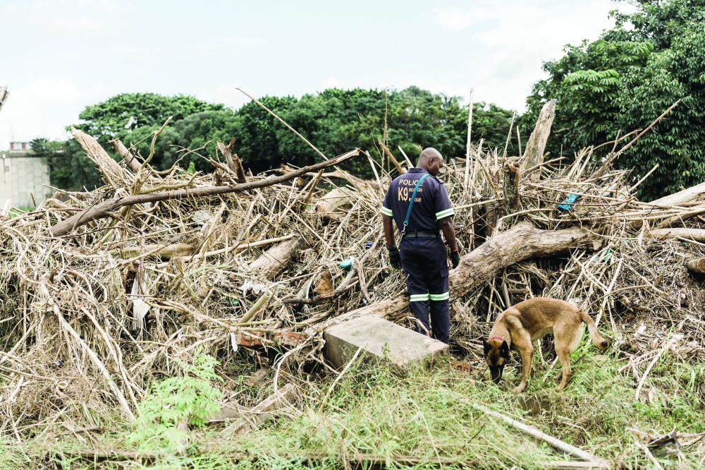 Members of the Disaster Management and other law enforcement agencies search for a missing person believed to be swept in a flood in Bellair north of Durban following heavy rains, mudslides in Durban. — AFP