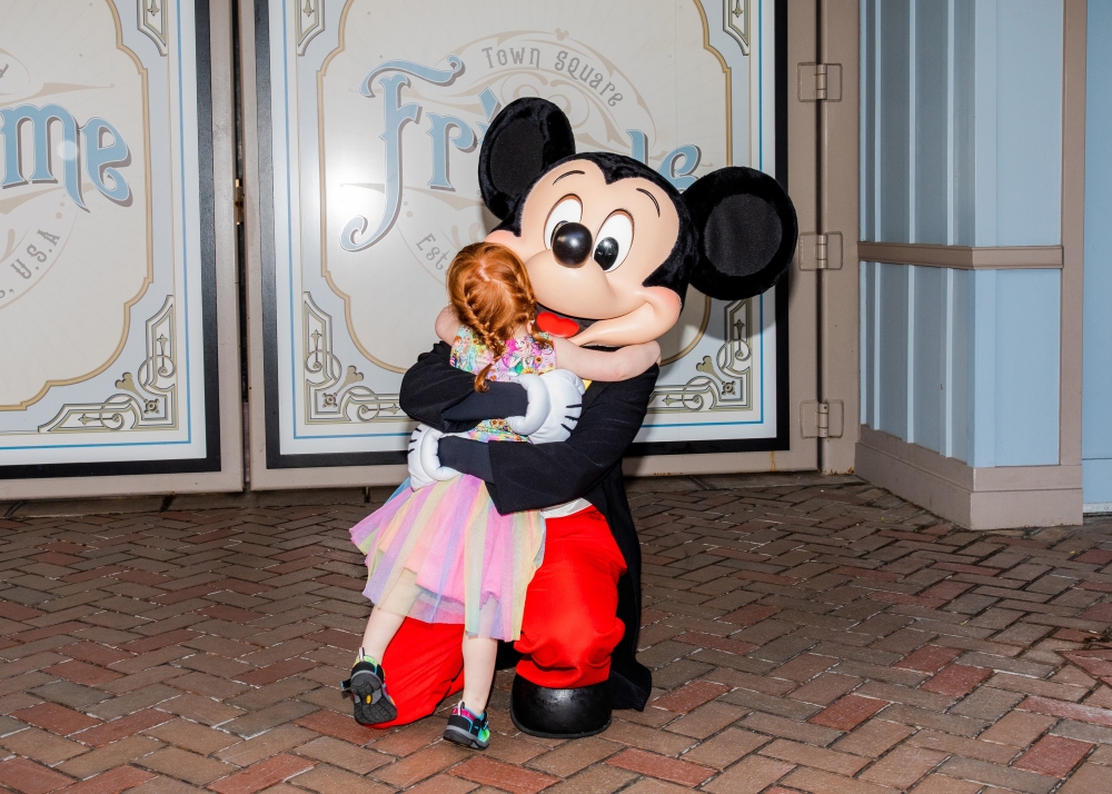 Mickey Mouse hugs Rory Sutherland at Disneyland in Anaheim, Calif., where a two-year ban on character embraces ended on Monday, April 18, 2022. (Alex Welsh/The New York Times)