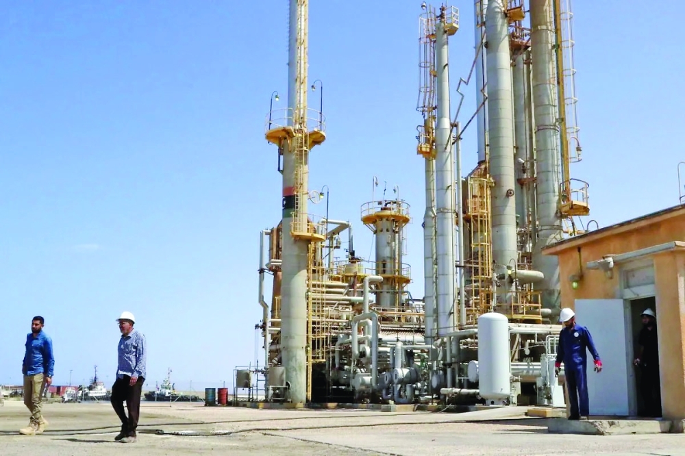 Workers are seen at an oil port in Tripoli, Libya.  — AFP