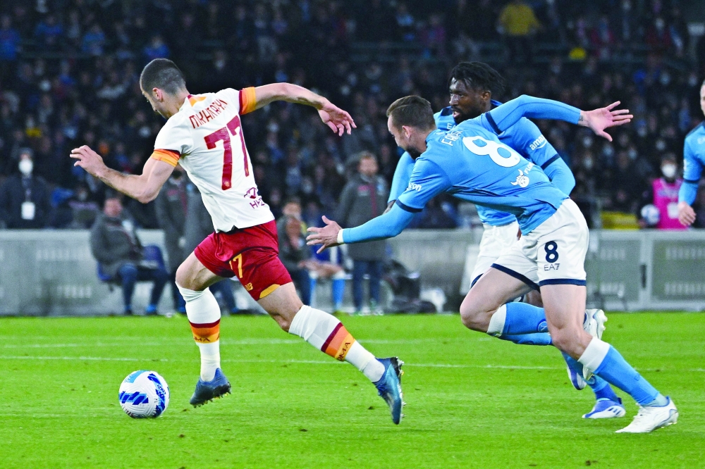 Roma's Armenian midfielder Henrikh Mkhitaryan (L) fights for the ball with Napoli's Spanish midfielder Fabian Ruiz during the Italian Serie A football match between SSC Napoli and Roma at the Diego Armando Maradona stadium in Naples on April 18, 2022.  (Photo by Andreas SOLARO / AFP)

