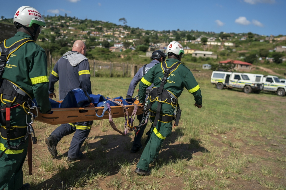 Members of a search-and-rescue team carry the body of a young flood victim recovered in Inanda, north of Durban, in Kwazulu-Natal Province in South Africa, April 18, 2021. (Joao Silva/The New York Times)