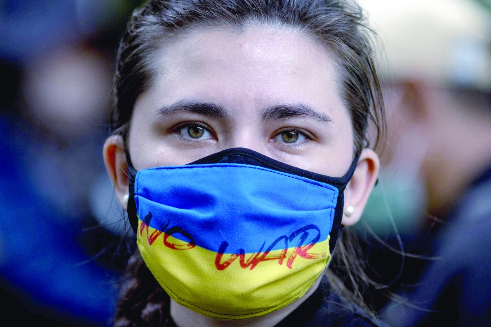 A protester wears a Ukrainian flag mask with the words "No War" during a demonstration outside the Russian Embassy in Bangkok on Wednesday. —  AFP