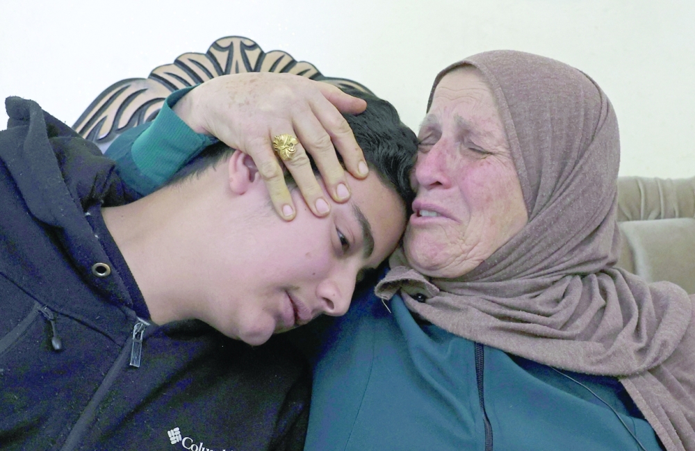 Houria Sabatien, mother of Palestinian woman Ghada Sabatien who was shot by an Israeli soldier, mourns with her grandchild Moustafa at their home in the village of Husan near Bethlehem. - AFP