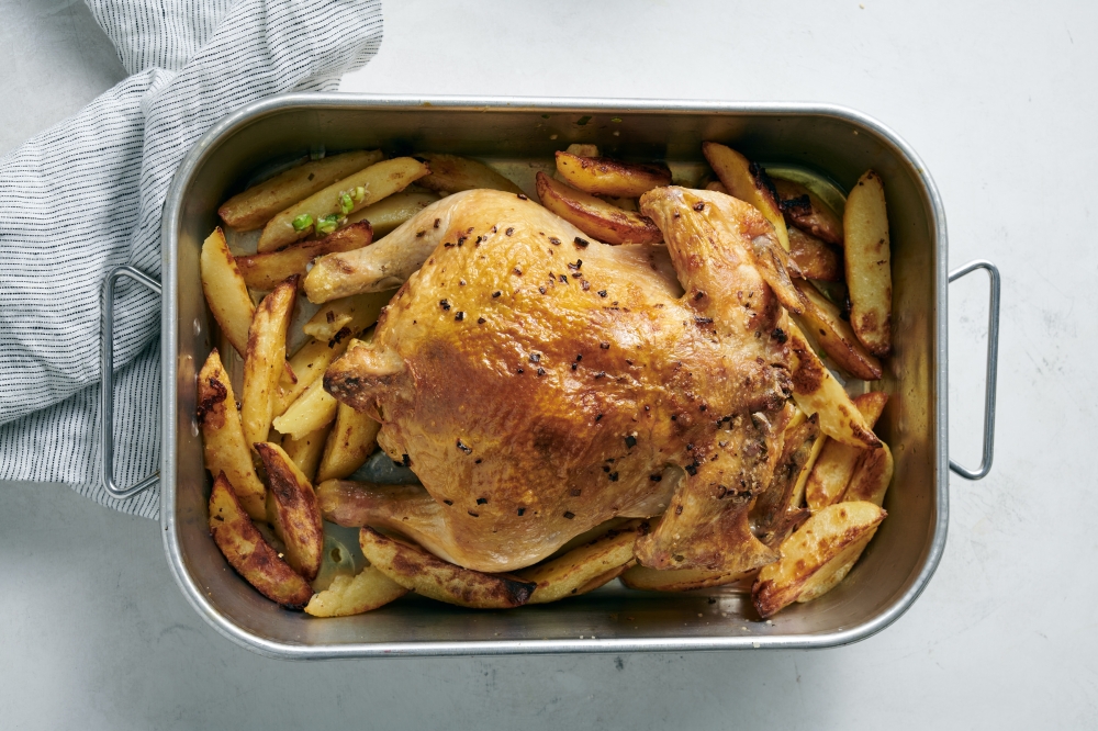 Roast chicken with green garlic, herbs and potatoes, in New York, March 31, 2022. Food styled by Simon Andrews. (David Malosh/The New York Times)
