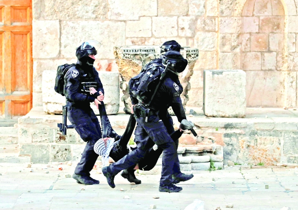 Israeli police arrest a Palestinian demonstrator at Al Aqsa mosque compound on Friday. - AFP

