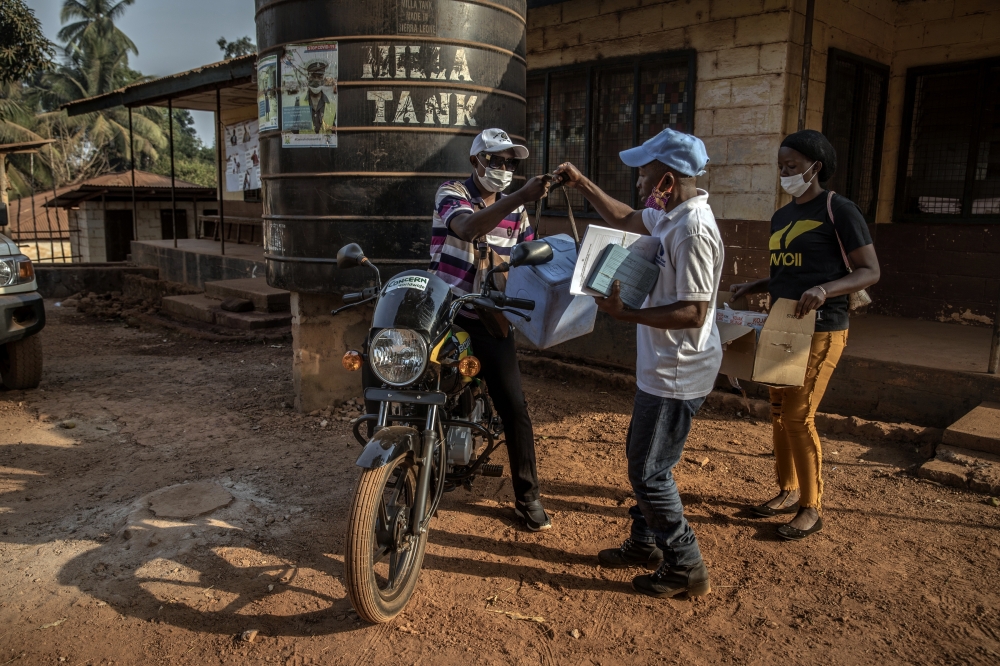Health workers in Kamakwie, Sierra Leone,  prepare a cooler of COVID-19 vaccines to be delivered to the village of Kathantha Yimbo on Feb. 15, 2022. (Finbarr O'Reilly/The New York Times)
