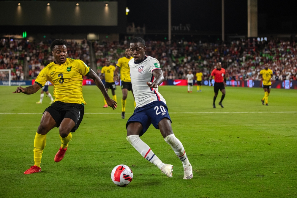 Javain Brown of Jamaica and Tim Weah of the U.S. mens national soccer teams during the 2022 World Cup qualifying match in Austin, Texas, Oct. 7, 2021. (Tamir Kalifa/The New York Times)