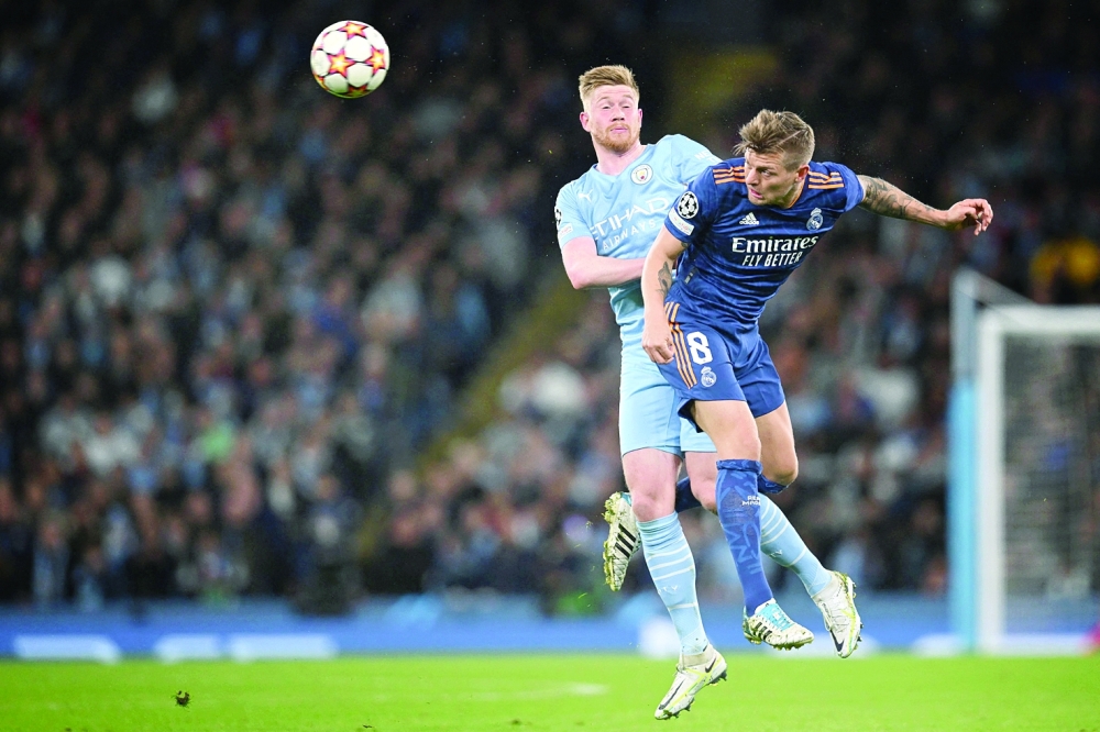 CORRECTION / Manchester City's Belgian midfielder Kevin De Bruyne (L) fights for the ball with Real Madrid's German midfielder Toni Kroos during the UEFA Champions League semi-final first leg football match between Manchester City and Real Madrid, at the Etihad Stadium, in Manchester, on April 26, 2022. (Photo by Paul ELLIS / AFP)

