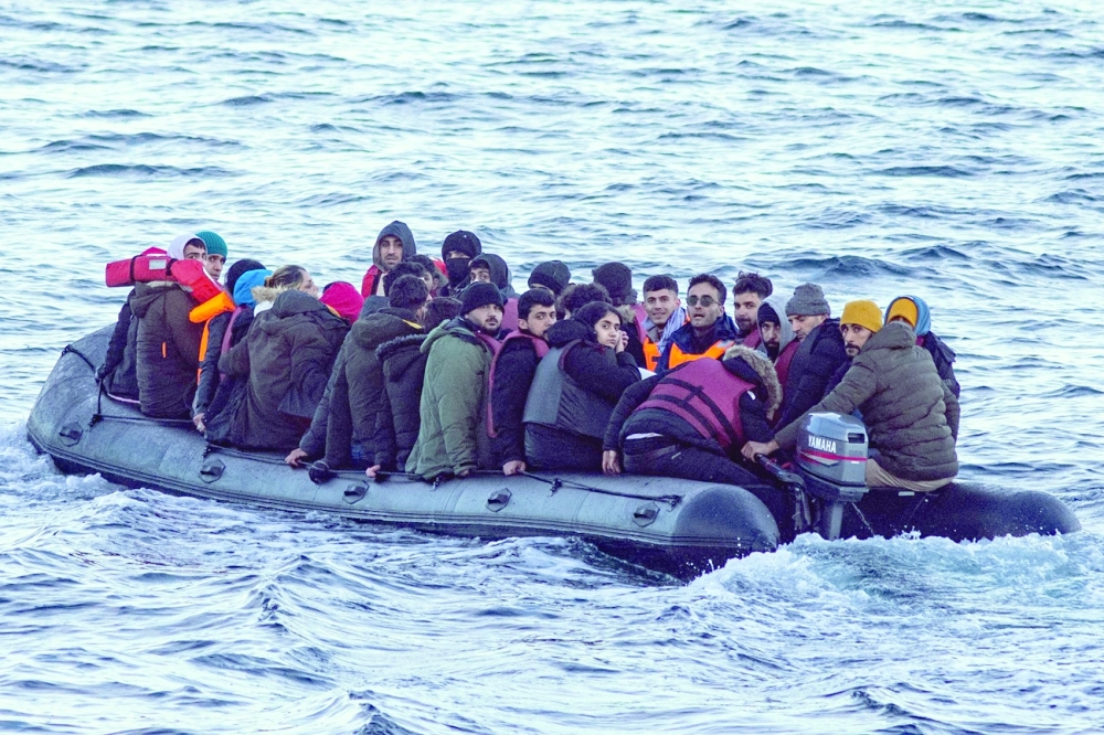 In this file photo taken on March 15 migrants sit in a dinghy as they illegally cross the English Channel from France to Britain. - AFP 